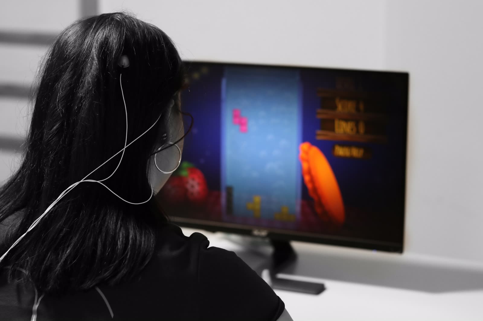 Patientin mit EEG-Elektroden während eines Neurofeedback-Trainings vor dem Feedback-Monitor